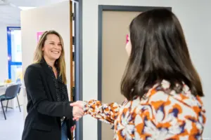 Formatrice en ligne de chez Écoris ONLINE, serrant la main d’un apprenant pour marquer le début d’un accompagnement.