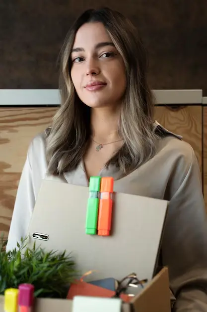 Employé tenant une boîte en carton, prêt à déménager ou à organiser des documents dans un environnement de bureau.