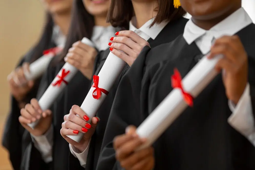 Personnes diplômées en gros plan, portant des chapeaux de diplômé et des robes de cérémonie
