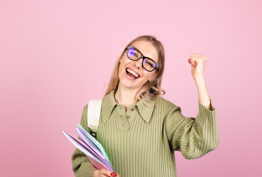 Étudiante souriante célébrant sa réussite après les examens avec un taux de réussite de 91 %.